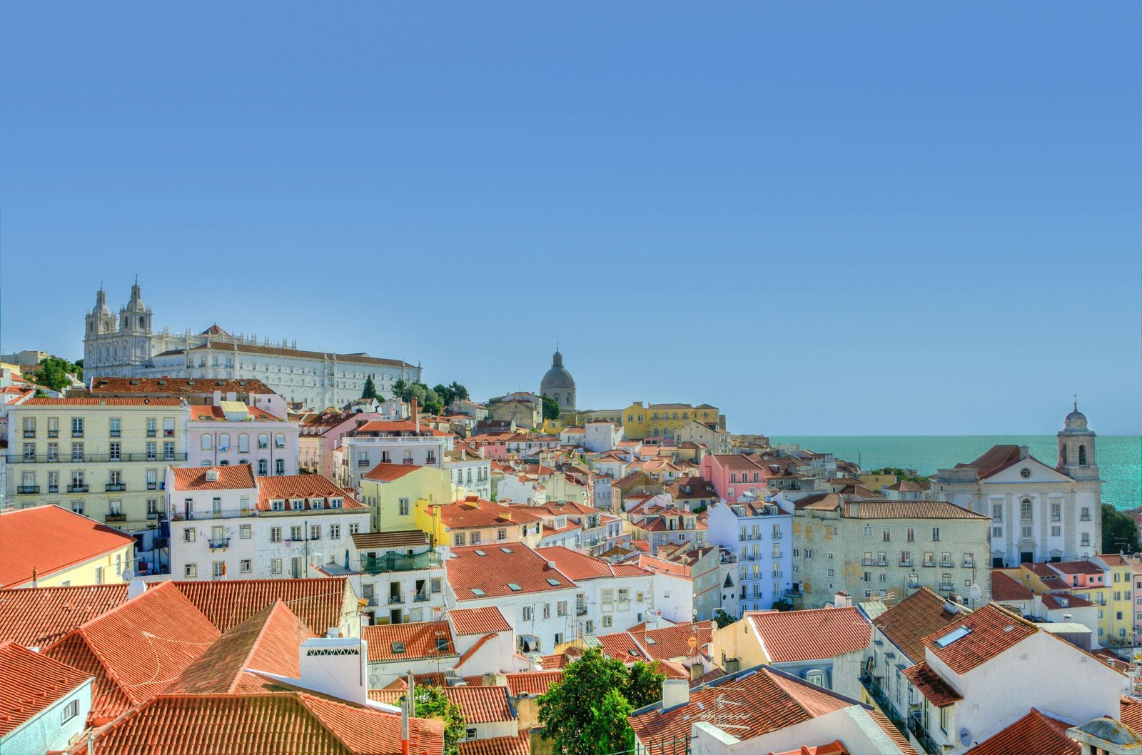 A stunning panoramic landscape view of Lisbon, Portugal, with red rooftops and the Tagus River, perfect for planning your 7 days in Lisbon.