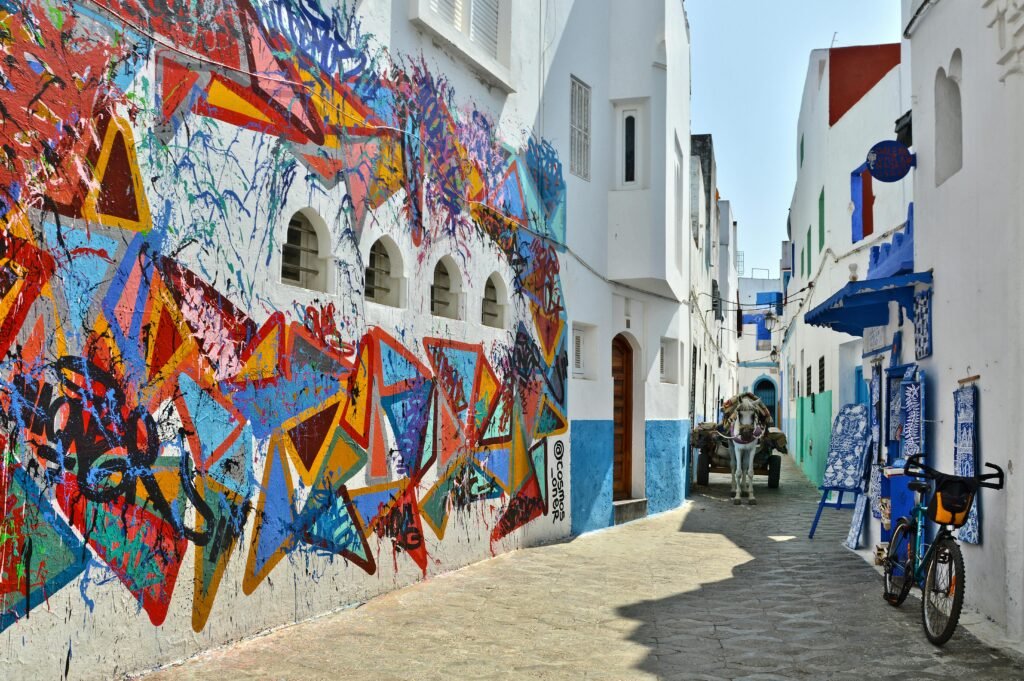 Colorful street mural in the medina of Assilah during the Assilah Art Festival, showcasing vibrant wall art and traditional Moroccan architecture